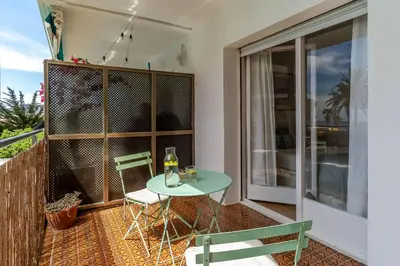 a patio with a table and chairs on a balcony at Canela Homes COSTA CASTELLDEFELS in Castelldefels