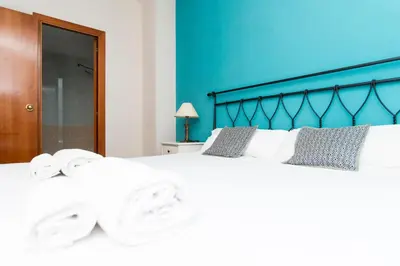 a bedroom with a large white bed with towels on it at Apartment Bright Sagrada Familia in Barcelona