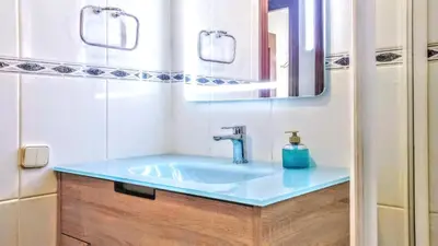 a bathroom with a blue sink and a mirror at Auditori Barcelona in Barcelona