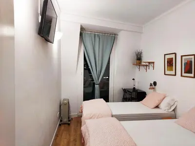 a bedroom with two beds and a tv and a window at Fira Suites in Barcelona