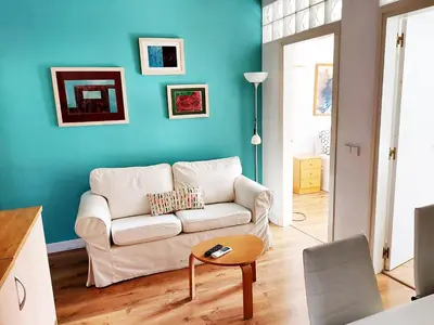 a living room with a white couch and a blue wall at Fira Suites in Barcelona