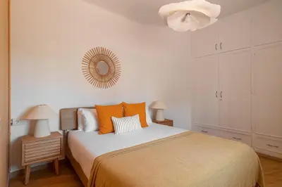 a bedroom with a bed with orange pillows and a mirror at Stay U-nique Apartments Gaudi III in Barcelona