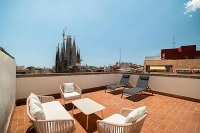 a patio with chairs and tables on a roof at Stay U-nique Apartments Gaudi III in Barcelona