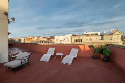 a balcony with two chairs and a table on a roof at Stay U-nique Apartments Gaudi III in Barcelona