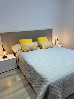 a bedroom with a large bed with yellow pillows at Nice Apartment 2 Bedrooms Well Connected in Cornellà de Llobregat