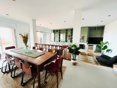 a living room with a wooden table and chairs at Villa Nova Vida Barcelona in Teià