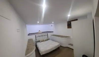 a small white room with a bed and a sink at Villa Urbina in Olerdola