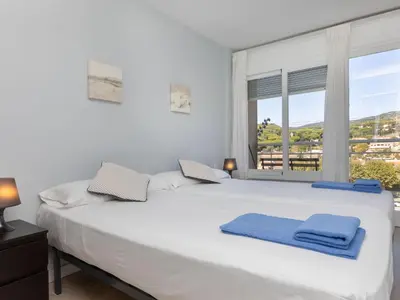 a bedroom with a large white bed with a window at Apartment Clipper by Interhome in Sant Vicenç de Montalt