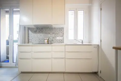 a white kitchen with white cabinets and a window at Catalunya Casas Lovely apartment central Barcelona 100m to beach! in Barcelona
