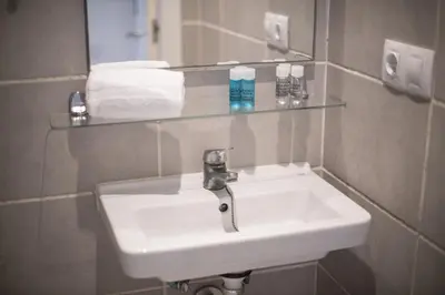 a bathroom sink with a glass shelf above it at Catalunya Casas Lovely apartment central Barcelona 100m to beach! in Barcelona
