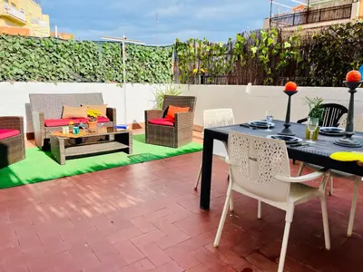 a patio with a table and chairs on a roof at Calm Terrace Barcelona in Barcelona