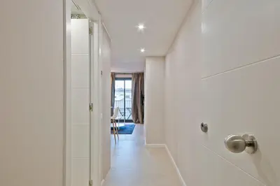 a white hallway with a door to a room at bonito piso cerca del campo de futbol de barcelona in Hospitalet de Llobregat