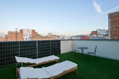 a balcony with two beds and a table and chairs at bonito piso cerca del campo de futbol de barcelona in Hospitalet de Llobregat