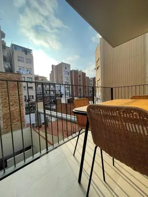 a balcony with a table and chairs and a view of a city at bonito piso cerca del campo de futbol de barcelona in Hospitalet de Llobregat