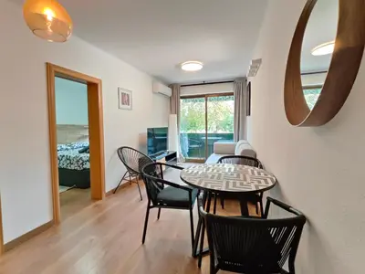 a dining room and living room with a table and chairs at Family apartment Besos 2 in Sant Adria de Besos