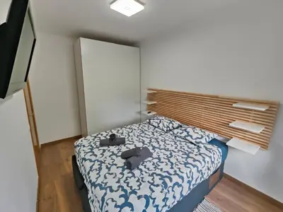 a small bedroom with a bed with a wooden headboard at Family apartment Besos 2 in Sant Adria de Besos