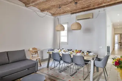 a dining room with a table and chairs and a couch at Canela Homes BARCELONA FONTANA in Barcelona