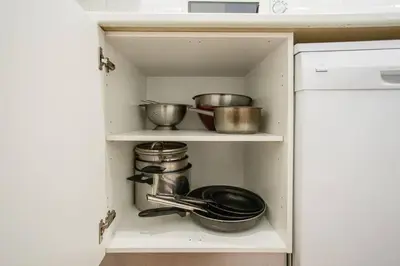 a cupboard with pots and pans in a kitchen at Canela Homes BARCELONA FONTANA in Barcelona