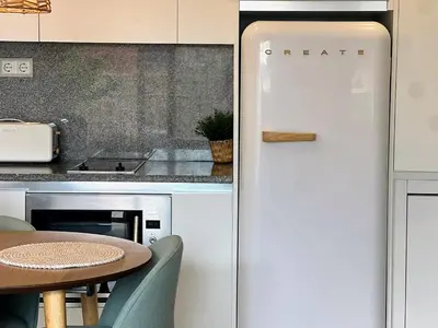 a white refrigerator in a kitchen with a table at Loft acogedor cerca de Barcelona in Terrassa