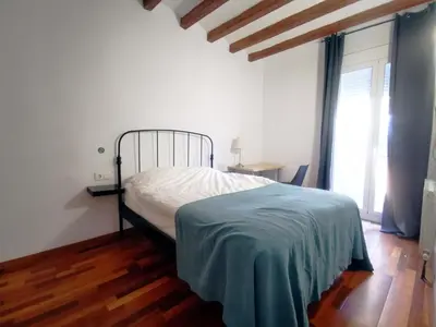 a bedroom with a bed in a room with wooden floors at VL51 in Barcelona