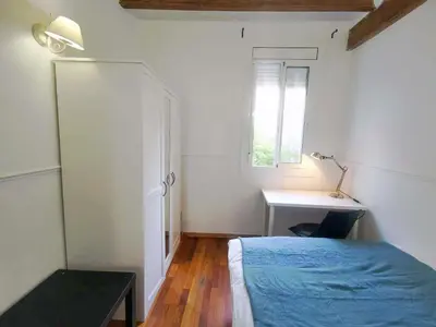 a bedroom with a bed and a desk and a window at VL51 in Barcelona