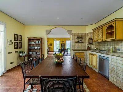 a large kitchen with a wooden table and chairs at Architectural jewel between sea and mountains in Teià