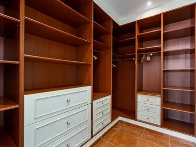 a walk in closet with wooden shelves and white drawers at Architectural jewel between sea and mountains in Teià