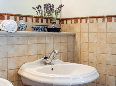 a white sink in a bathroom with vases on a shelf at Architectural jewel between sea and mountains in Teià
