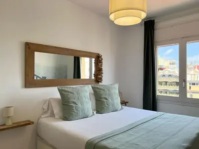 a bedroom with a bed with a mirror and a window at Stay U-nique Apartments Rambla Catalunya V in Barcelona
