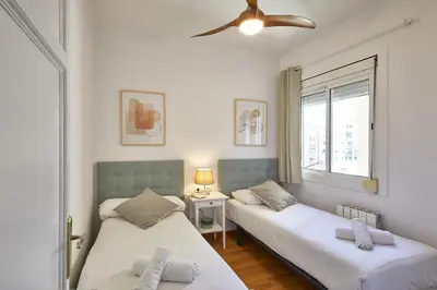 a bedroom with two beds and a ceiling fan at BBarcelona Central Eixample Flat in Barcelona