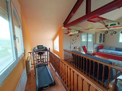 a room with a balcony with a view of a living room at Casa con jardín y piscina privada. in Santa Eulalia de Ronsaná