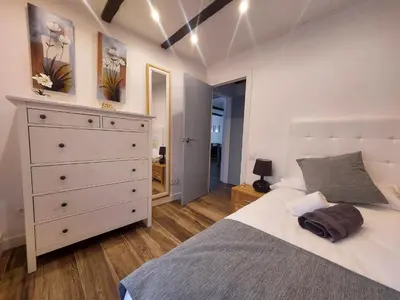 a bedroom with a white bed and a dresser at Cerca de Barcelona, y entre tres Parques Naturales, casa de 4 habitaciones y 2 baños con piscina, barbacoa y chimenea in San Antonio de Vilamajor