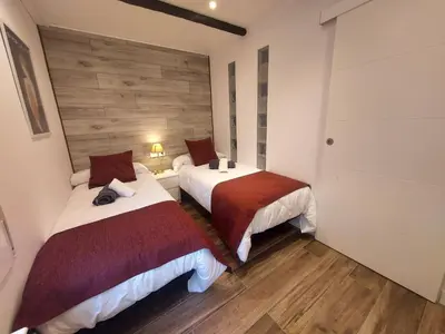 two beds in a room with wooden floors at Cerca de Barcelona, y entre tres Parques Naturales, casa de 4 habitaciones y 2 baños con piscina, barbacoa y chimenea in San Antonio de Vilamajor