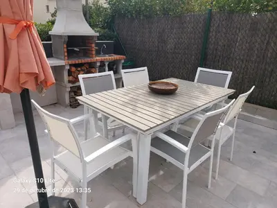 a wooden table and chairs on a patio at Cerca de Barcelona, y entre tres Parques Naturales, casa de 4 habitaciones y 2 baños con piscina, barbacoa y chimenea in San Antonio de Vilamajor
