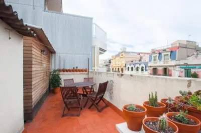 a balcony with a table and chairs and potted plants at Ático con encanto, centro, con aparcamiento in Barcelona