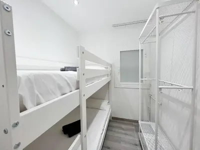 a white bunk bed and a ladder in a room at Cosy Montroig Sitges in Sitges