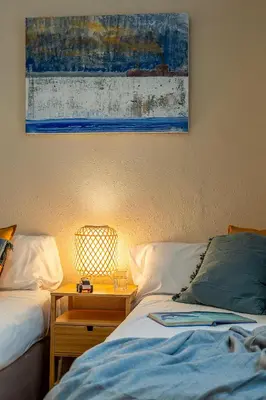 a bedroom with two beds and a table with a picture on the wall at Canela Homes BARCELONA FIRA in Barcelona