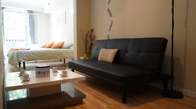a living room with a black couch and a table at Good-Home Paseo de Gracia in Barcelona