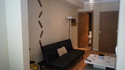 a living room with a black couch and a table at Good-Home Paseo de Gracia in Barcelona