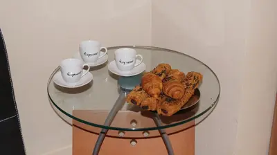 a glass table with coffee cups and pastries on it at Good-Home Paseo de Gracia in Barcelona