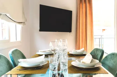 a dining room with a table with chairs and a television at Soler Apartments in Sant Adria de Besos