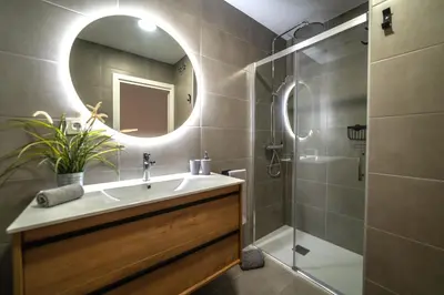 a bathroom with a sink and a shower and a mirror at Soler Apartments in Sant Adria de Besos