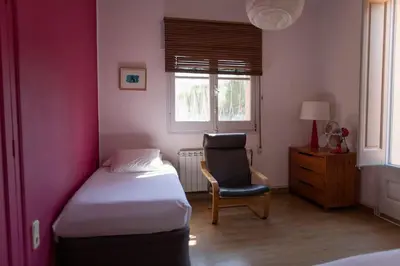 a bedroom with a bed and a chair and a window at casabelladona in Sant Cugat del Vallès