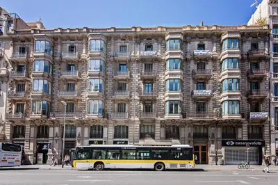 a bus parked in front of a large building at Plaza Catalunya in Barcelona