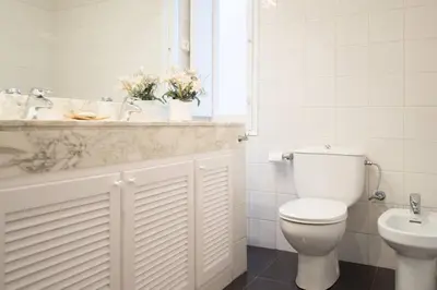 a white bathroom with a toilet and a sink at FANTASTIC apartment in Barcelona in Barcelona