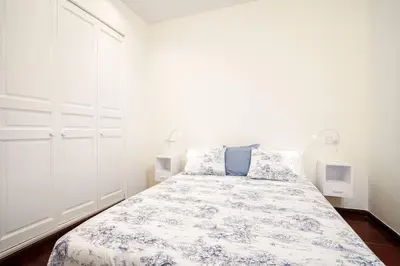 a bedroom with a bed with a blue and white comforter at FANTASTIC apartment in Barcelona in Barcelona