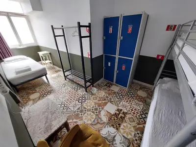 a room with two bunk beds and a floor with tiles at Alberg Sants Bcn in Barcelona
