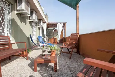 a patio with benches and a table with a bottle of wine at Stay U-nique Apartments Marina III in Barcelona