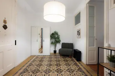 a hallway with a chair and a potted plant at Stay U-nique Apartments Granados in Barcelona