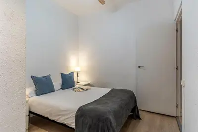 a bedroom with a white bed with blue pillows at 1690 - AB Eixample Rosselló in Barcelona